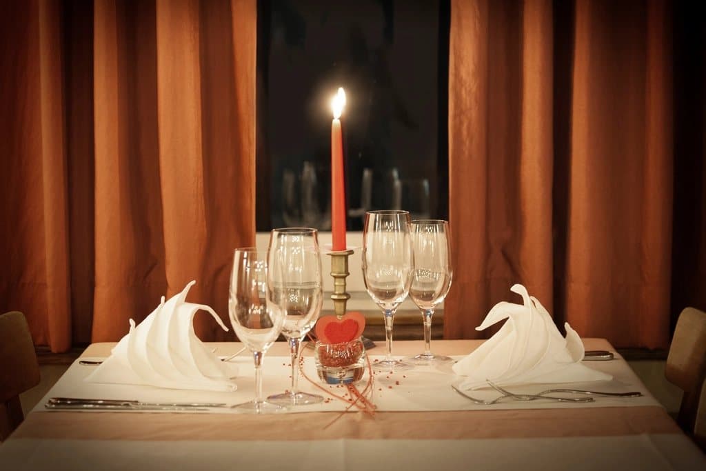 Mesa posta para um jantar romântico com velas e flores